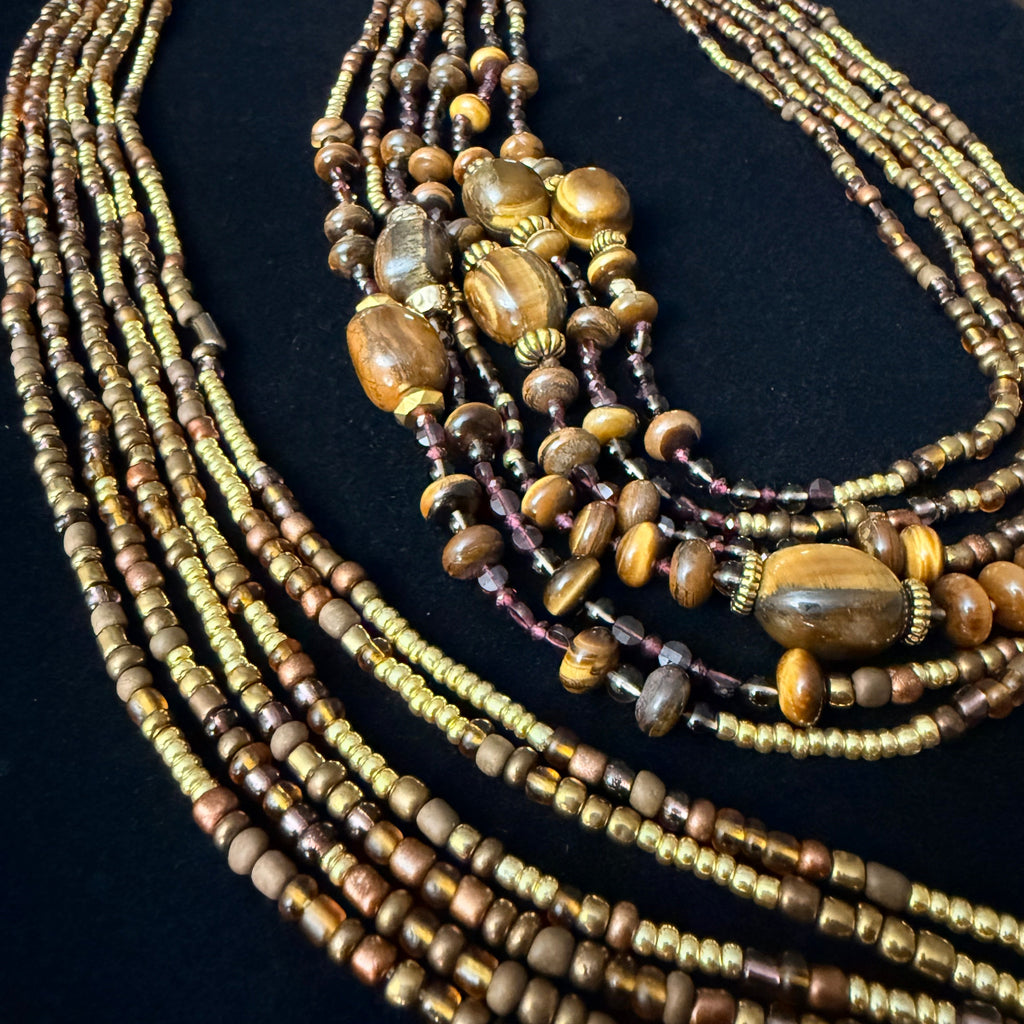 Multiple beaded necklaces on a black stand