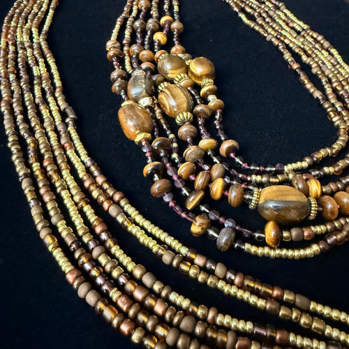 Multiple beaded necklaces on a black stand