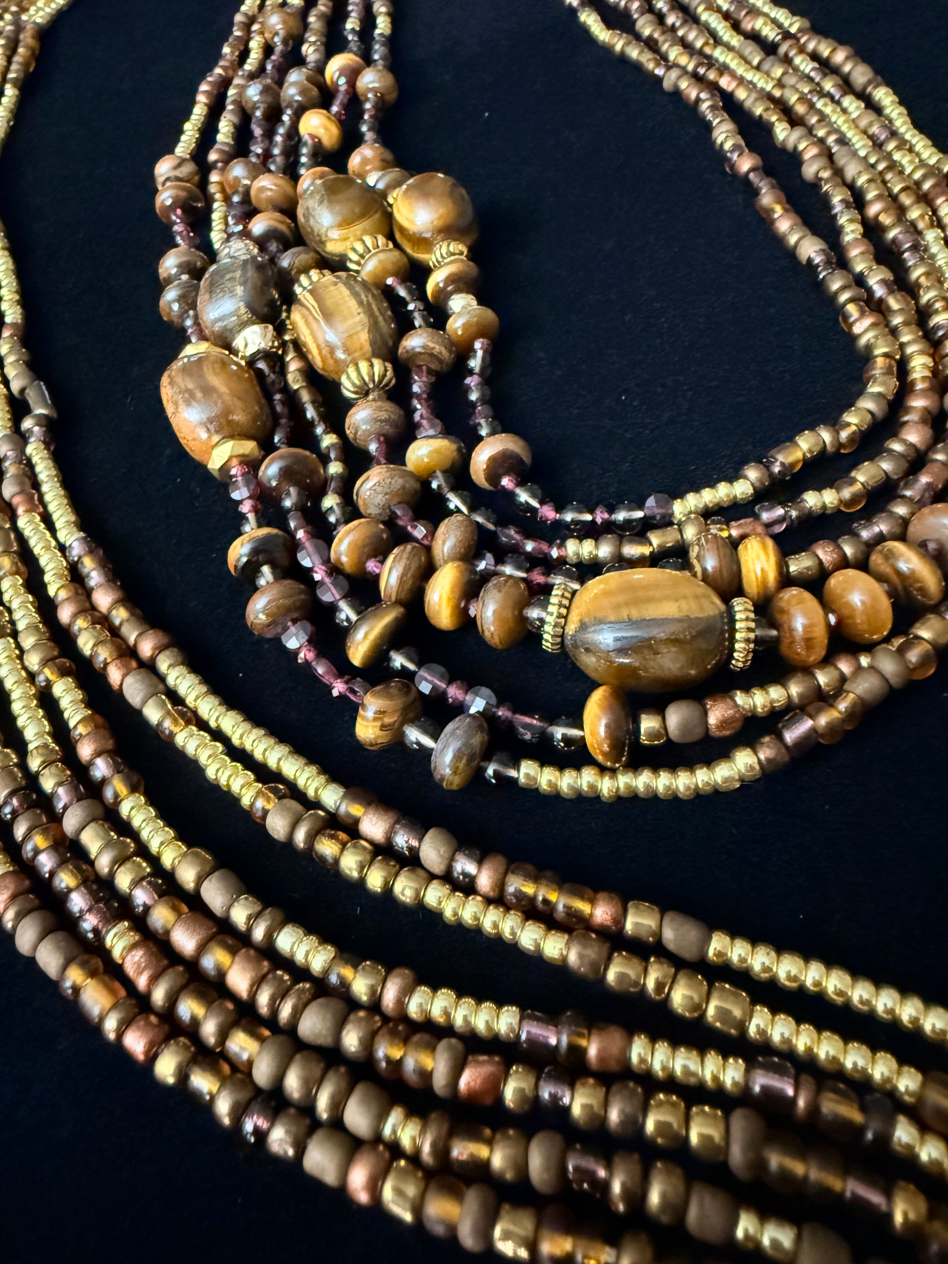 Beaded necklaces with various stones on a dark background