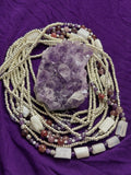 Beaded necklaces with a crystal on a purple fabric background